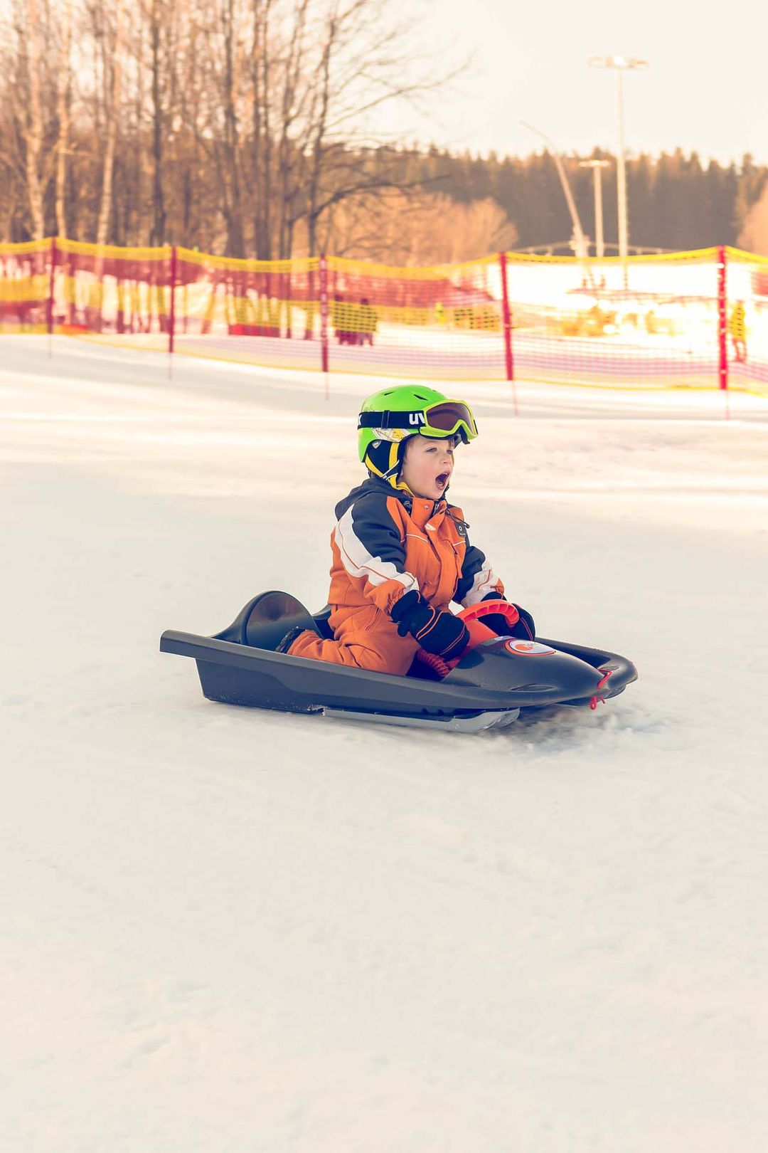 Wexl Arena – St Corona am Wechsel in Austria - a young boy riding on a snowmobile in the snow.