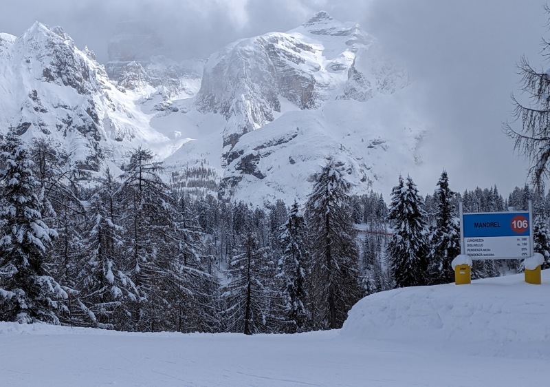 A skier gliding down a slope at a Pila ski resort in Aosta, Italy. The backdrop showcases snowy, scenic mountains, creating an idyllic winter sports scene.
