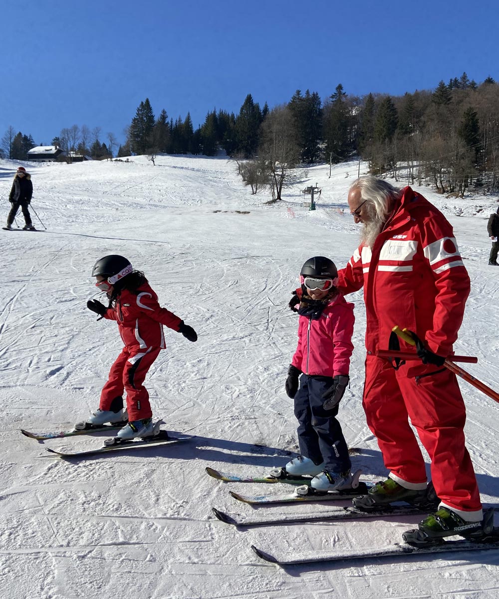 Montmin in France - a group of people skiing down a snow covered hill.