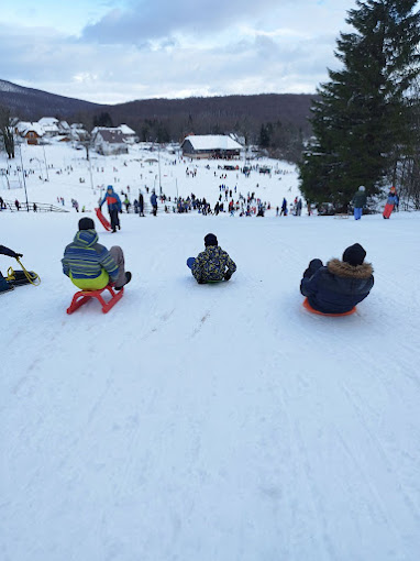 ŠRC Mukinje in Croatia - a group of people riding down a snow covered slope.