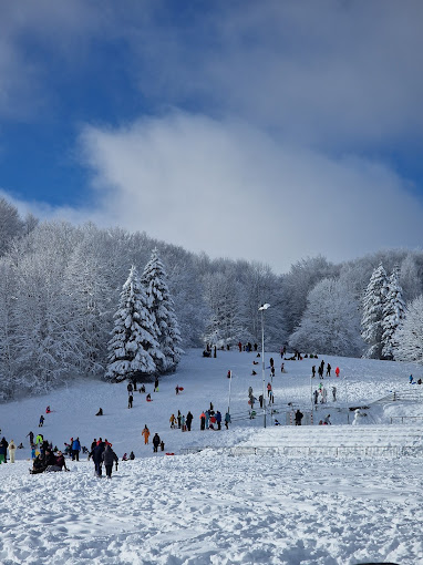ŠRC Mukinje in Croatia - a group of people skiing down a snow covered hill.