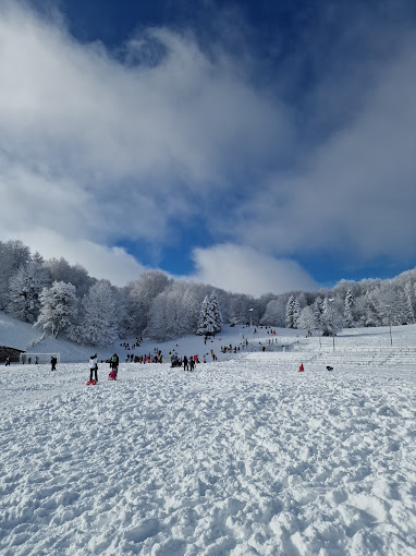 ŠRC Mukinje in Croatia - a group of people skiing down a snow covered hill.