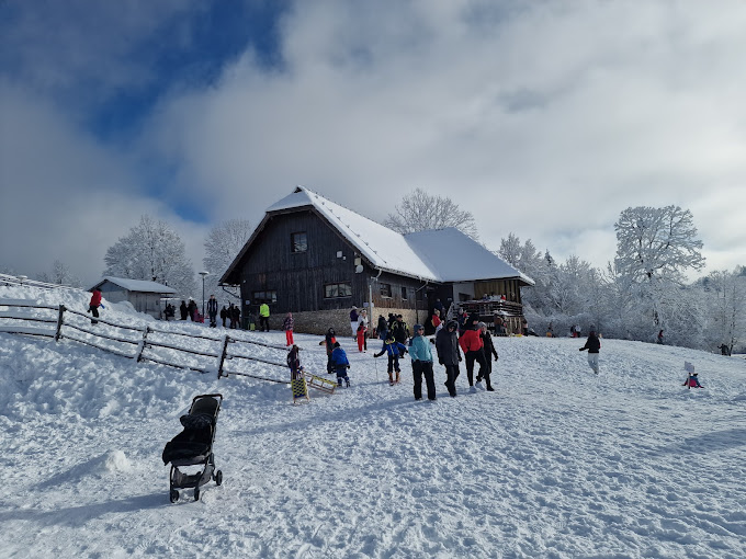 ŠRC Mukinje in Croatia - a group of people standing on top of a snow covered hill.