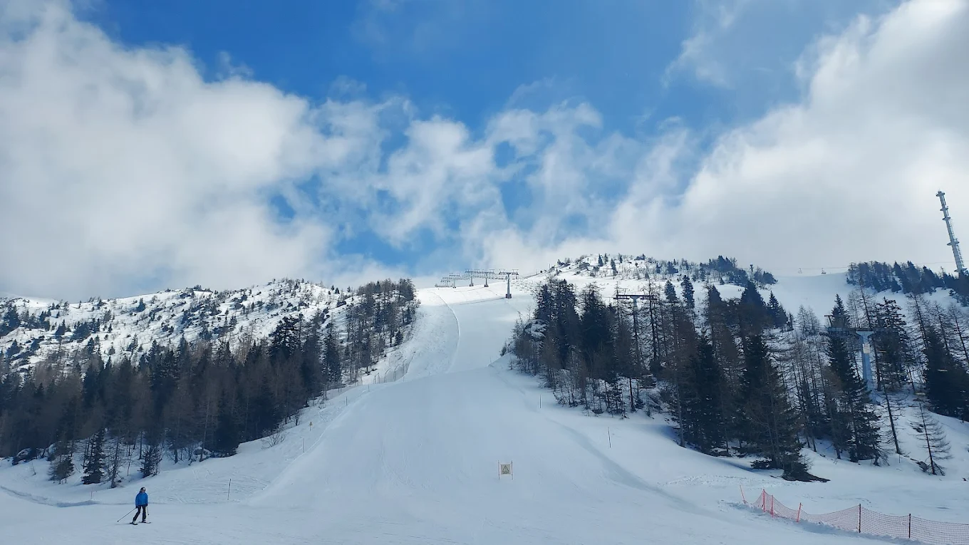 Krvavec in Slovenia - a person skiing down a snow covered mountain.