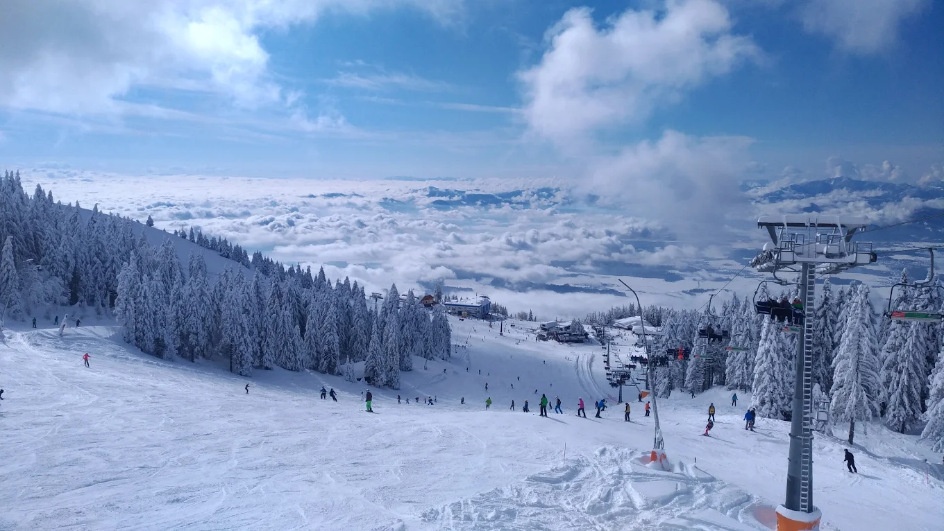 Krvavec in Slovenia - a ski slope with people skiing down it.