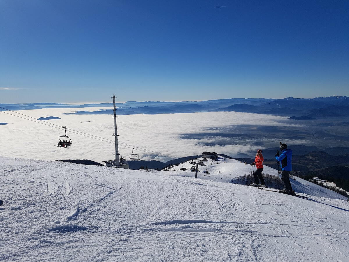 Krvavec in Slovenia - a group of people standing on top of a snow covered mountain.