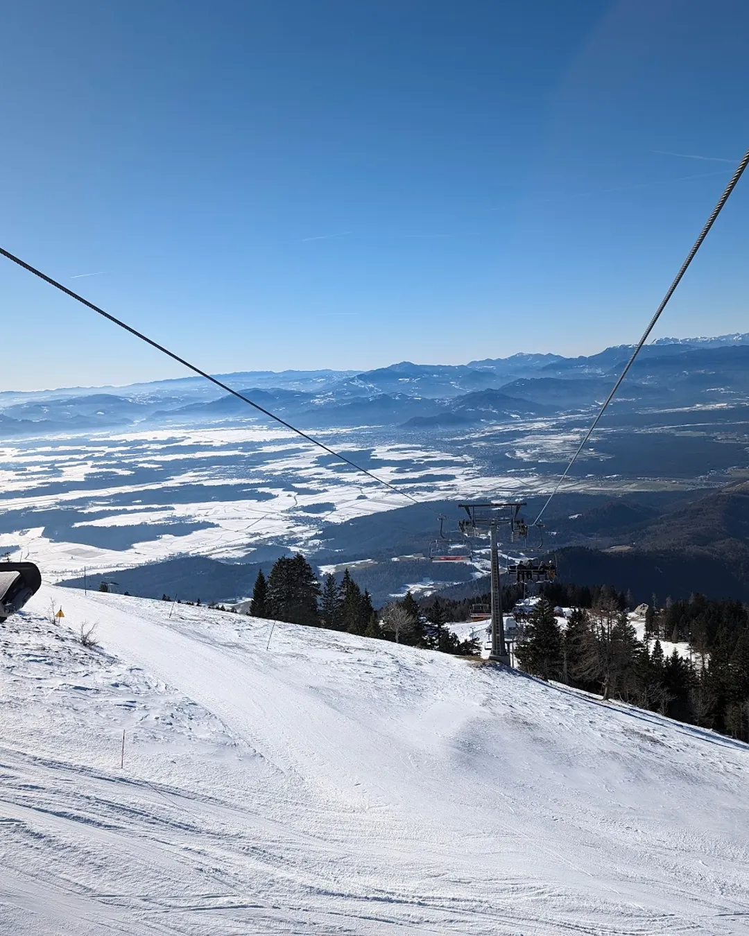 Krvavec in Slovenia - a person on a ski lift going down the mountain.