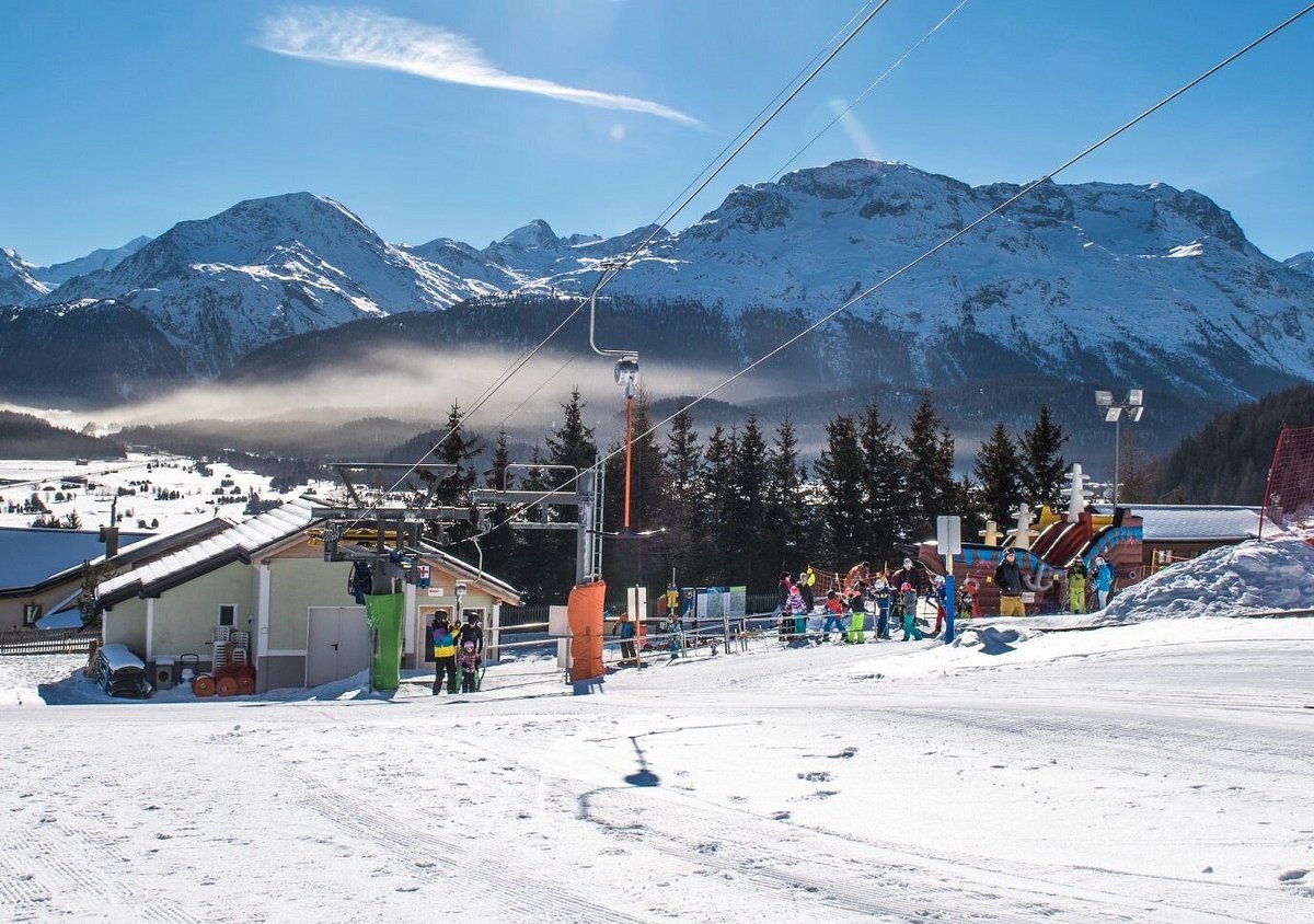 Survih – Samedan in Switzerland: people are skiing on the slopes of a ski resort.