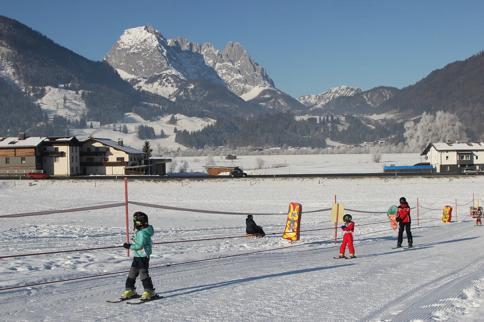 Kirchdorf in Austria - a group of people riding ski boards across a snow covered field.
