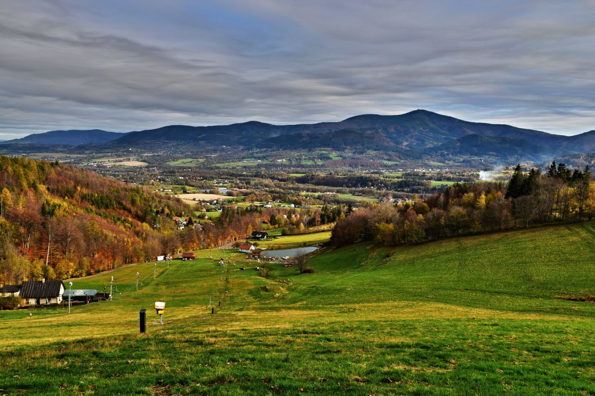 Opálená in Czech Republic - a green field with mountains in the background.