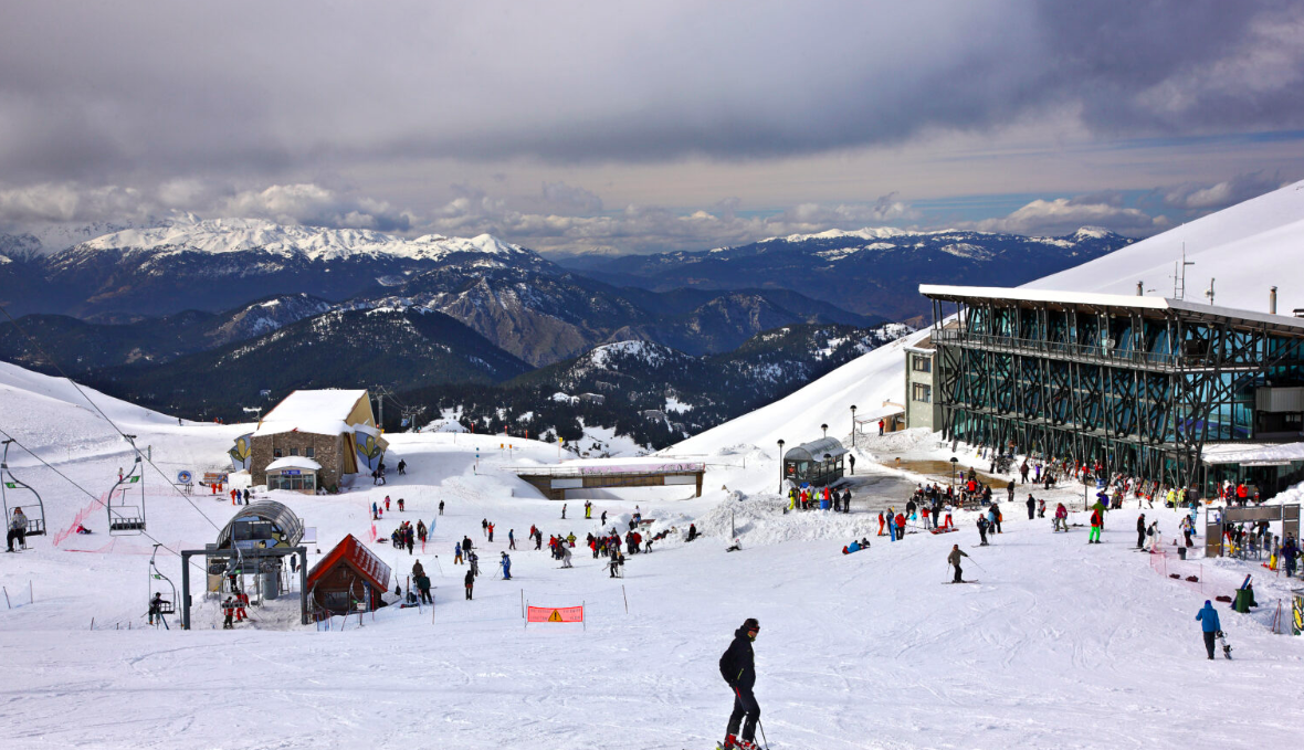 Mount Parnassos – Fterolakka | ​Kellaria in Greece - a group of people skiing down a snow covered mountain.