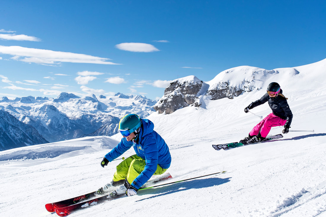 Zlaim – Grundlsee in Austria - a couple of people riding down a snow covered slope.