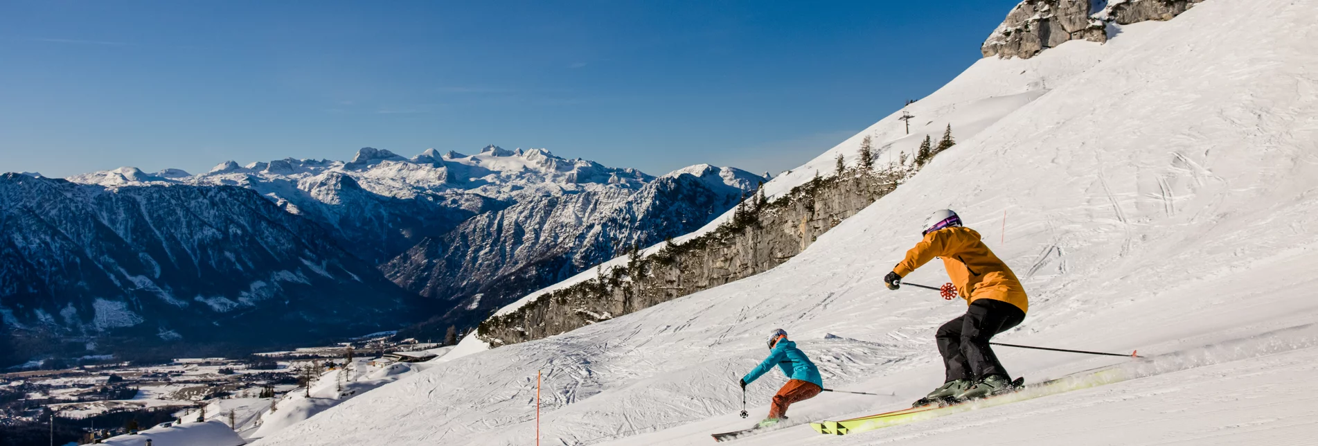 Zlaim – Grundlsee in Austria - two people skiing down a snowy mountain.