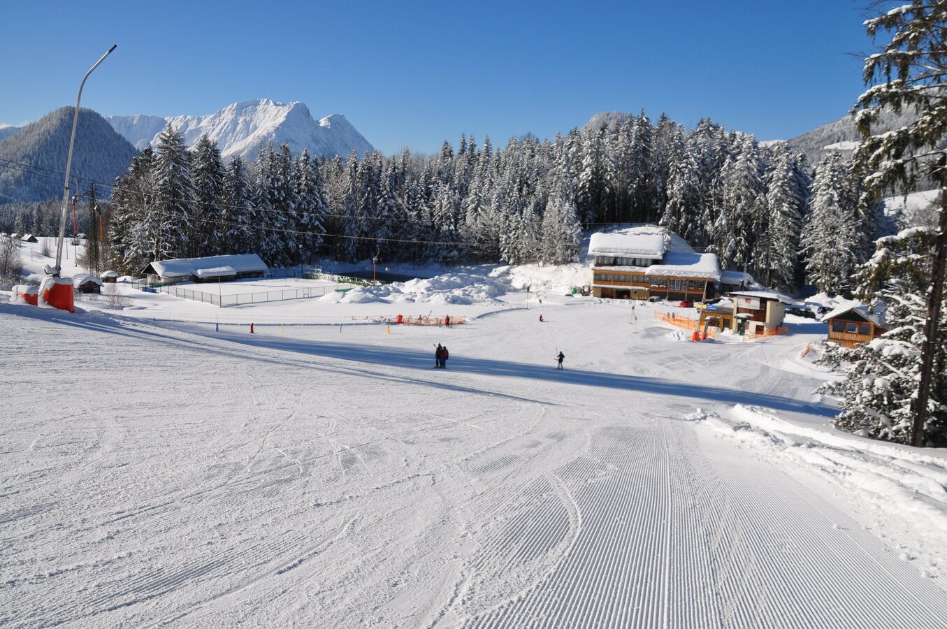Zlaim – Grundlsee in Austria - a snow covered ski slope with trees in the background.