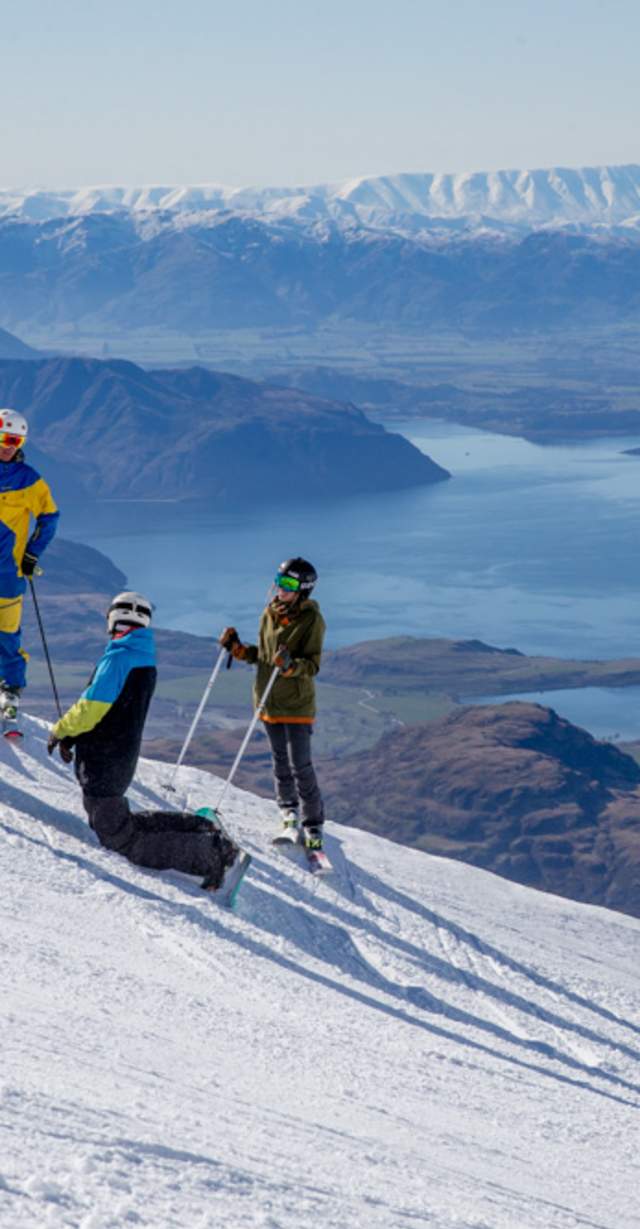 Treble Cone in New Zealand - a group of people skiing down a mountain.