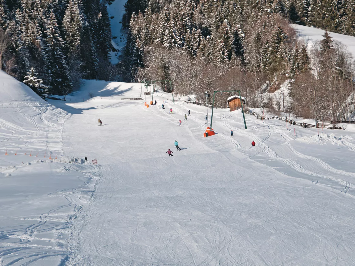 Sonnenberglift – Gries im Sellrain in Austria - a group of people skiing down a mountain.