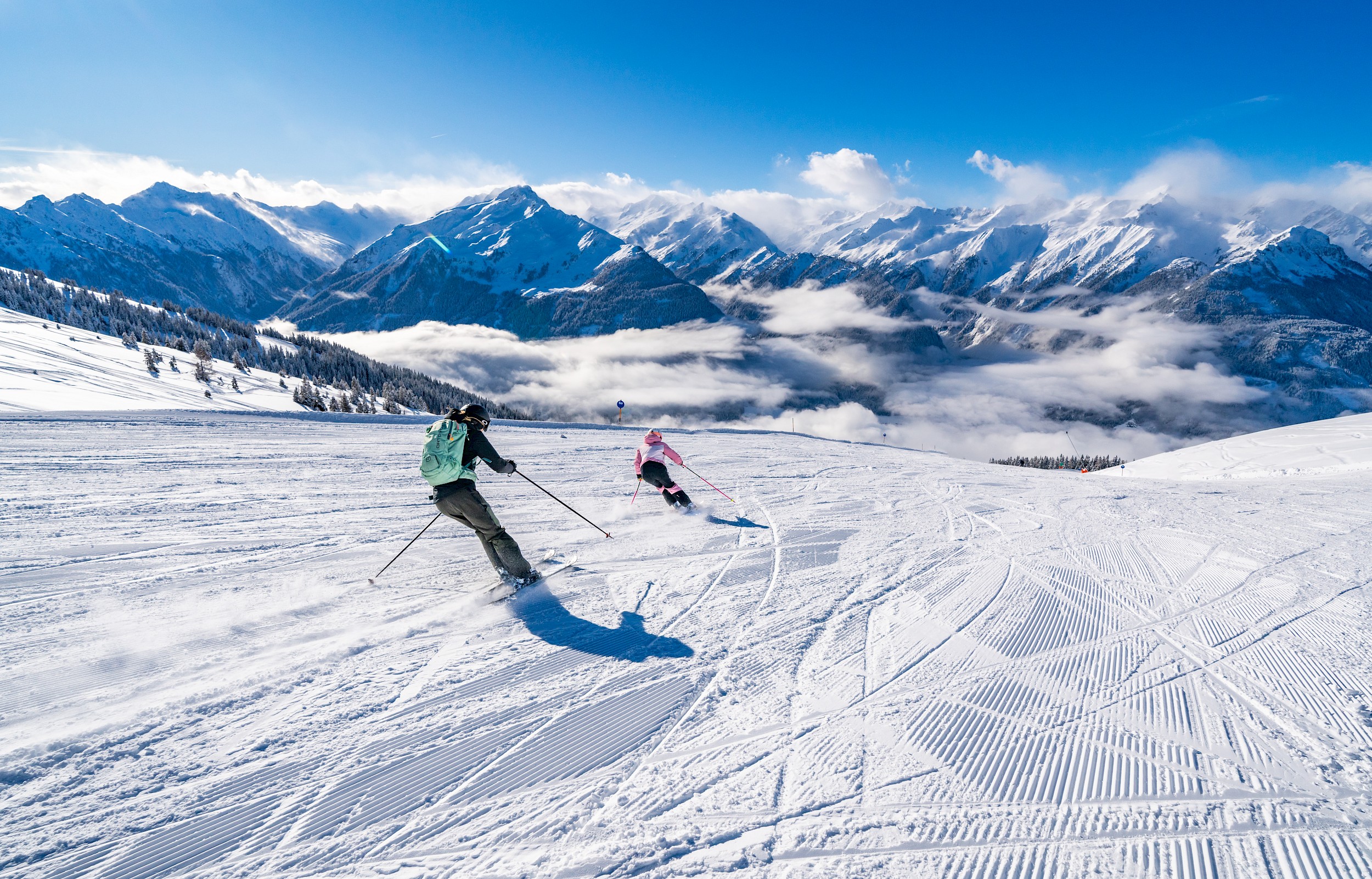 Wildkogel in Austria - a couple of people skiing down a snowy slope.