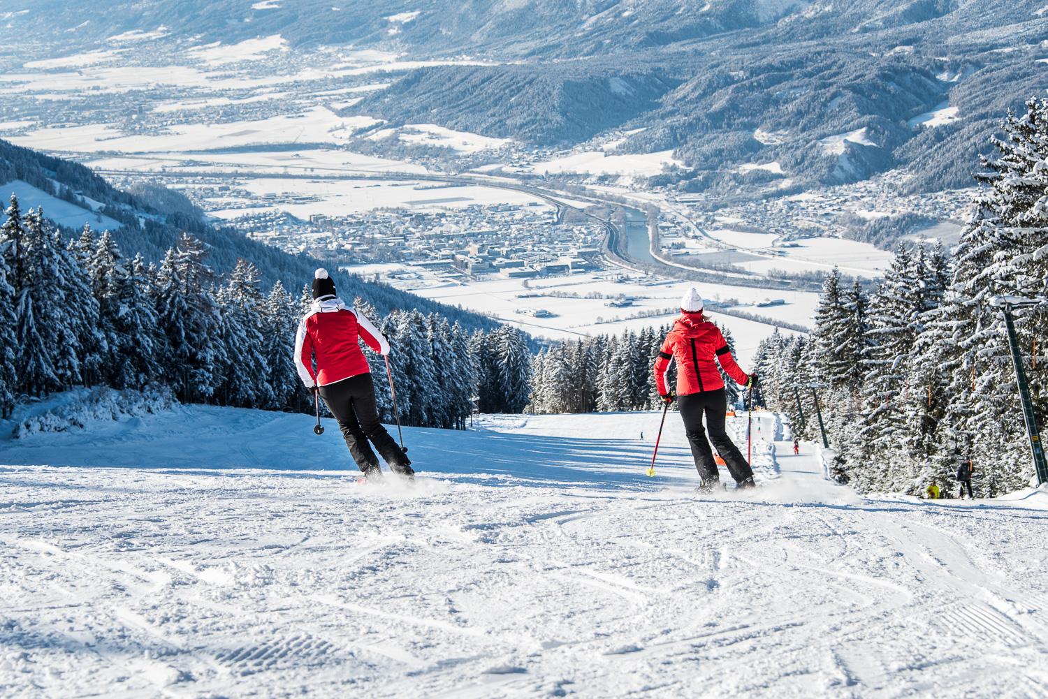 Schwannerlift – Weerberg in Austria - two people skiing down a snowy slope in the mountains.