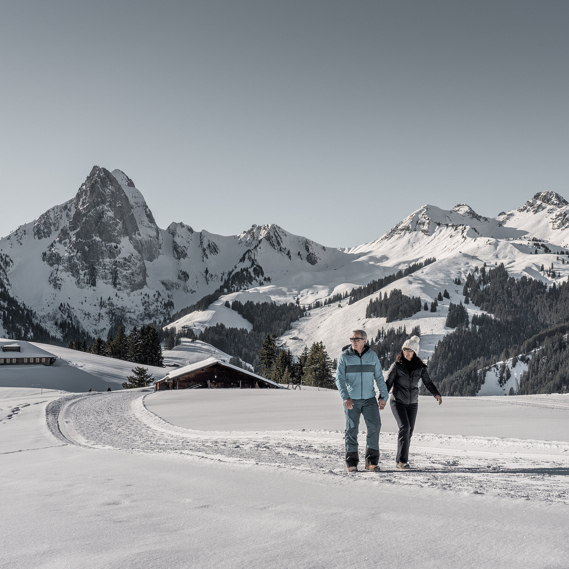 Winter sports scene in Gstaad, Bern, Switzerland featuring breathtaking winter scenery, a noticeable mountain range, and a charming chalet.