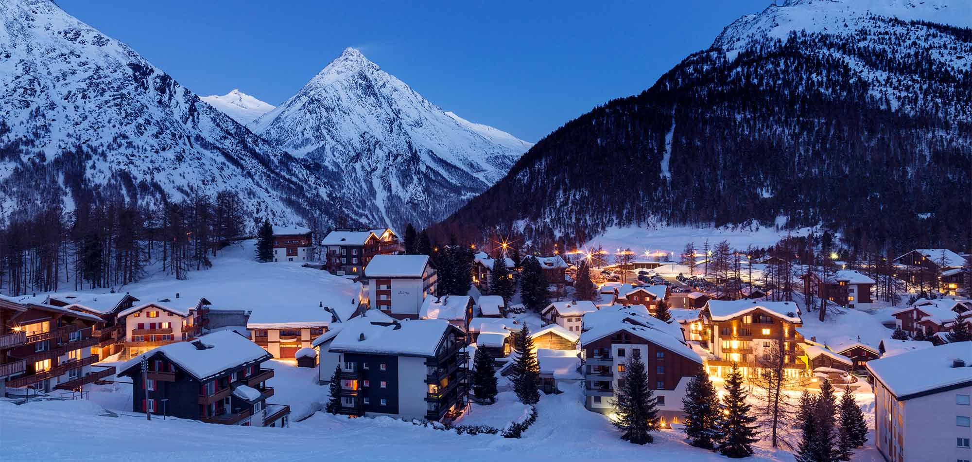 Gstaad in Switzerland - a snowy town with mountains in the background.