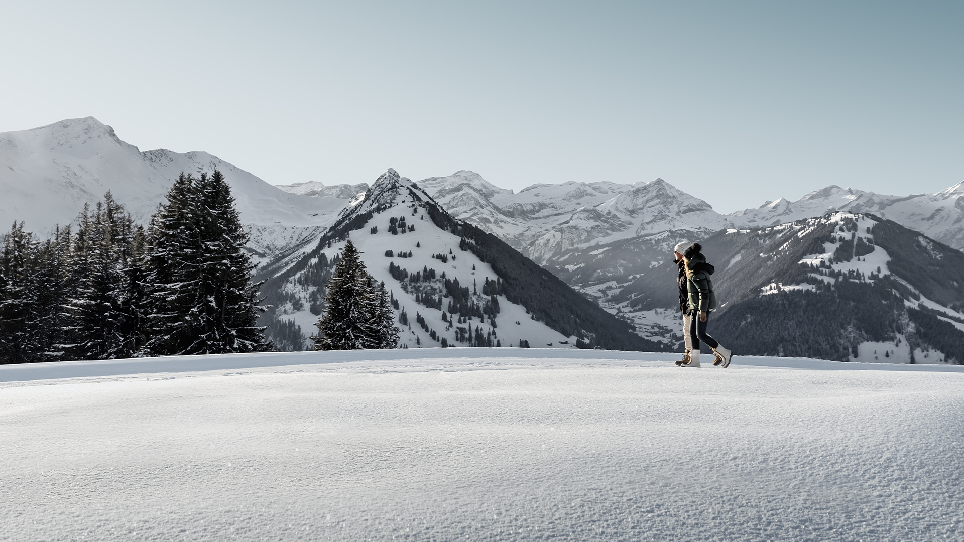 A skier enjoying winter sports amidst a stunning winter landscape in Gstaad, Bern, Switzerland, with the winter sports centre in the backdrop.