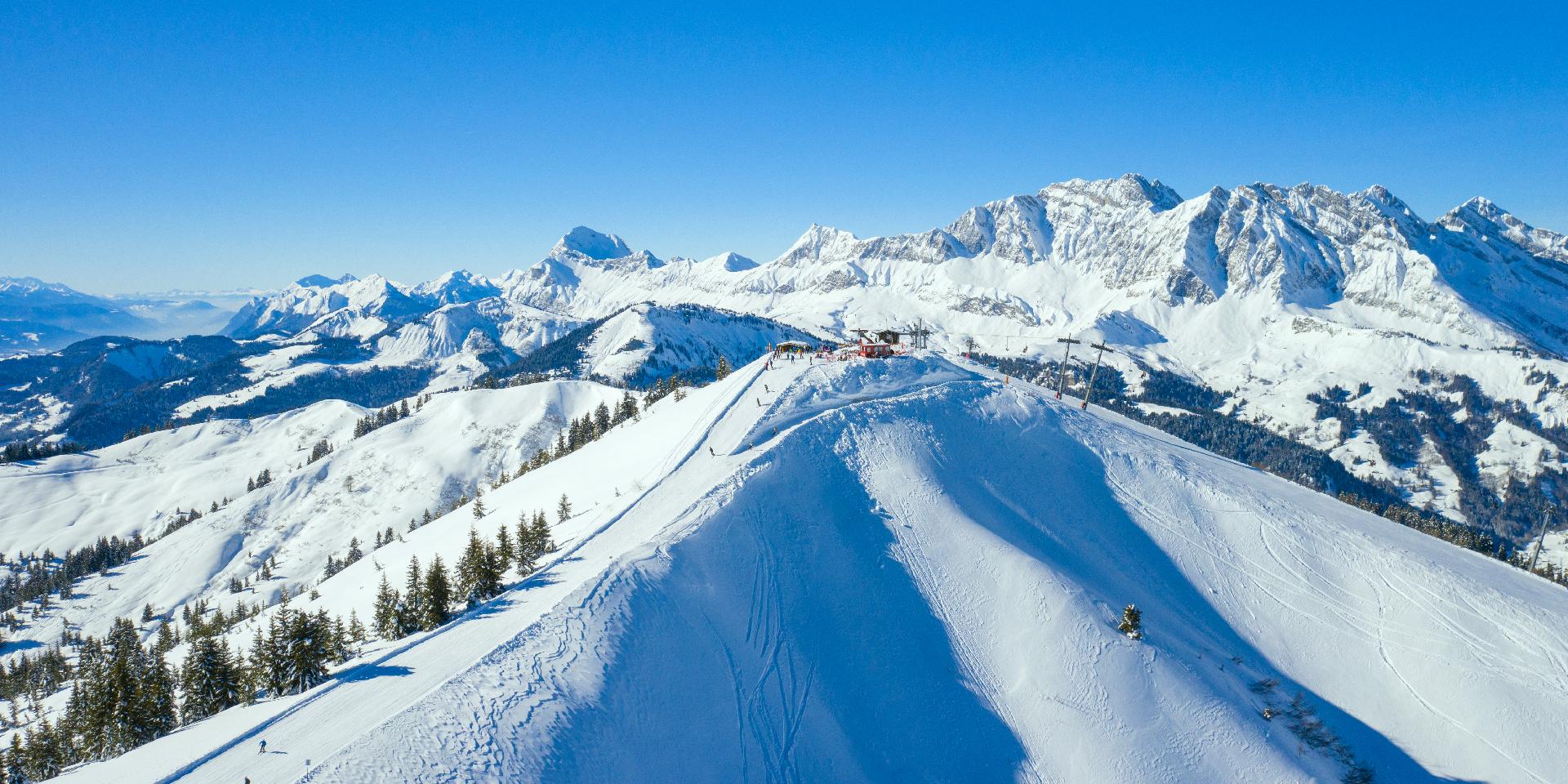 Les Portes du Mont-Blanc in France - a person skiing down a snowy slope in the mountains.
