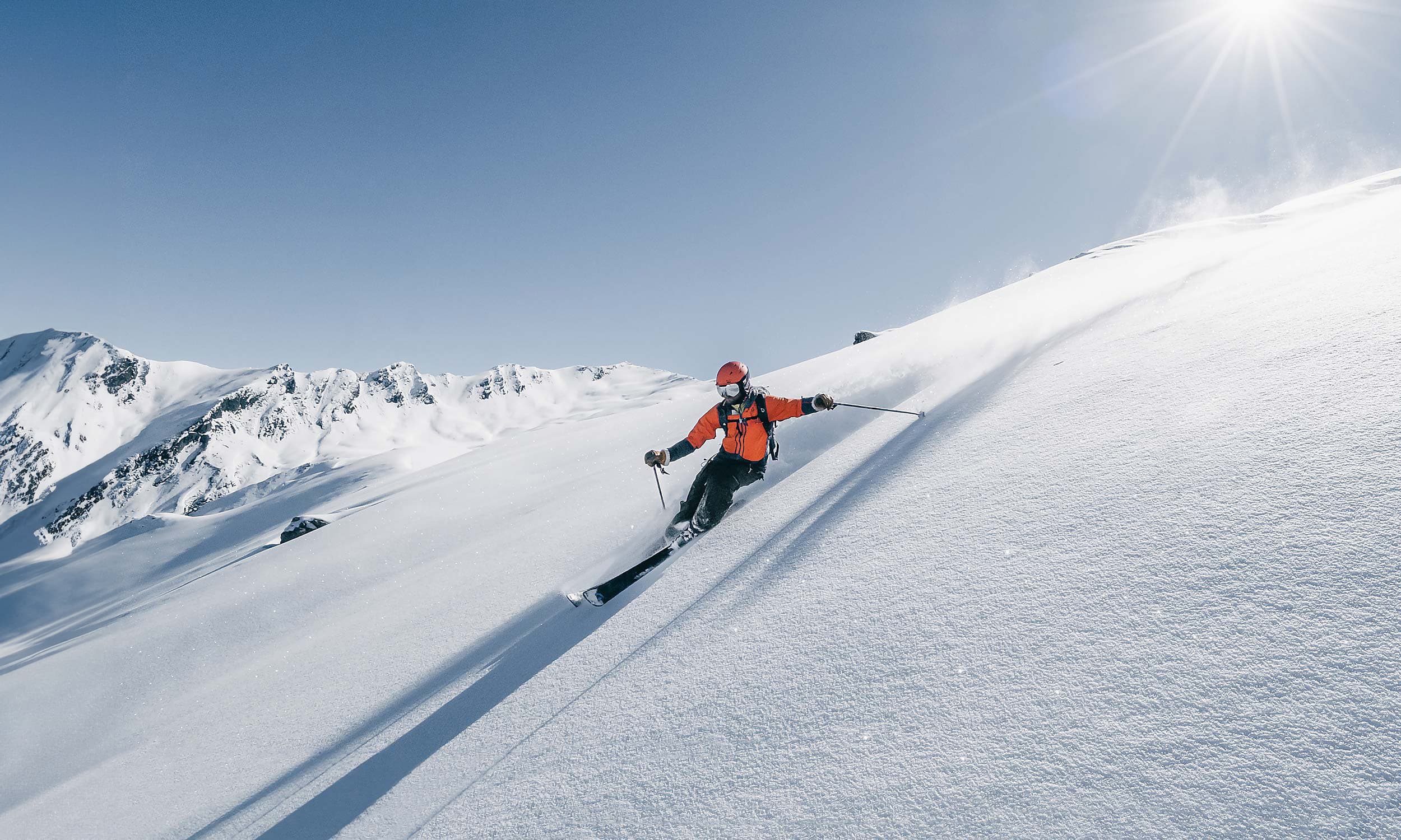 A skier navigating the snowy slopes of Valfréjus ski resort in Savoie Mont Blanc, France, surrounded by picturesque alpine scenery.