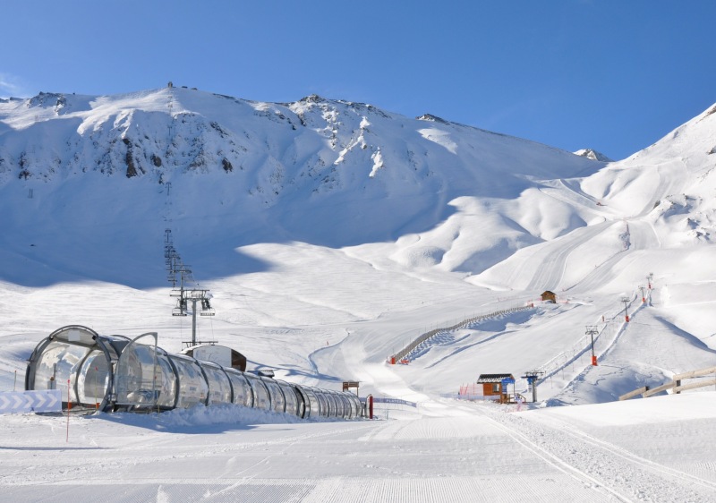 Ski resort scene in Valfréjus, Savoie Mont Blanc, France, featuring winter sport activities, a chalet, and breathtaking snowy landscapes.