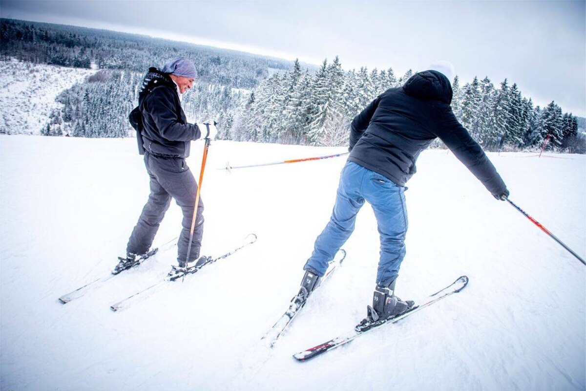 Thier des Rexhons – Spa in Belgium - two people are skiing down a snowy hill.