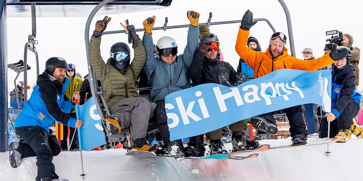 A skier gliding down the snowy slopes at the charming Sugar Bowl Ski Resort in Lake Tahoe, California. Several other skiers can be spotted in the distance, as well as a scenic ski lift.