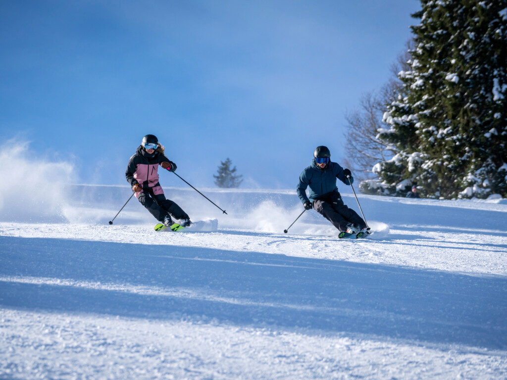 Winterberglifte – Schonach im Schwarzwald in Germany - two people are skiing down a snowy hill.