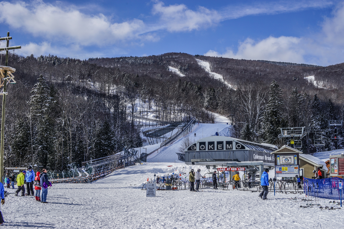 Okemo Mountain Resort in USA - a group of people standing in the snow.