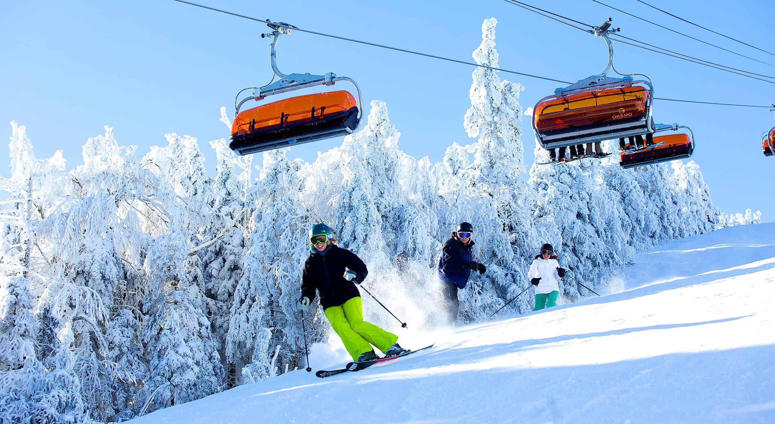 Okemo Mountain Resort in USA - a group of people skiing down a snowy slope.