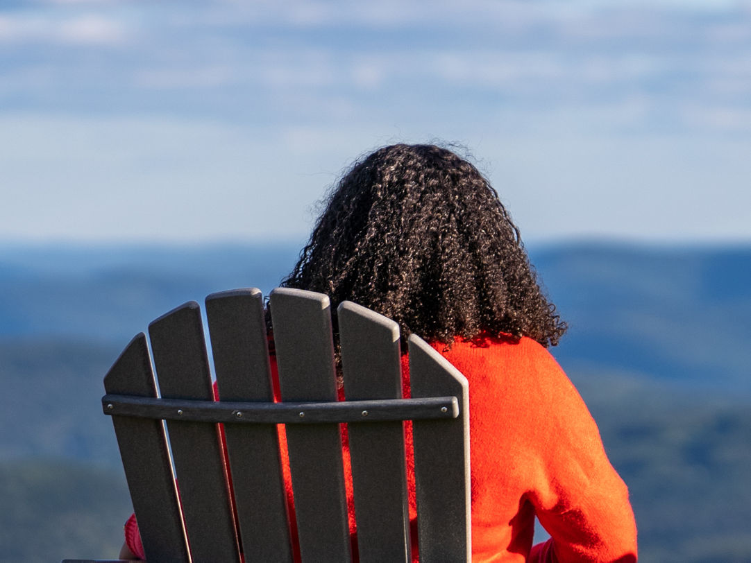 Okemo Mountain Resort in USA - a woman sitting in a chair looking out over the mountains.