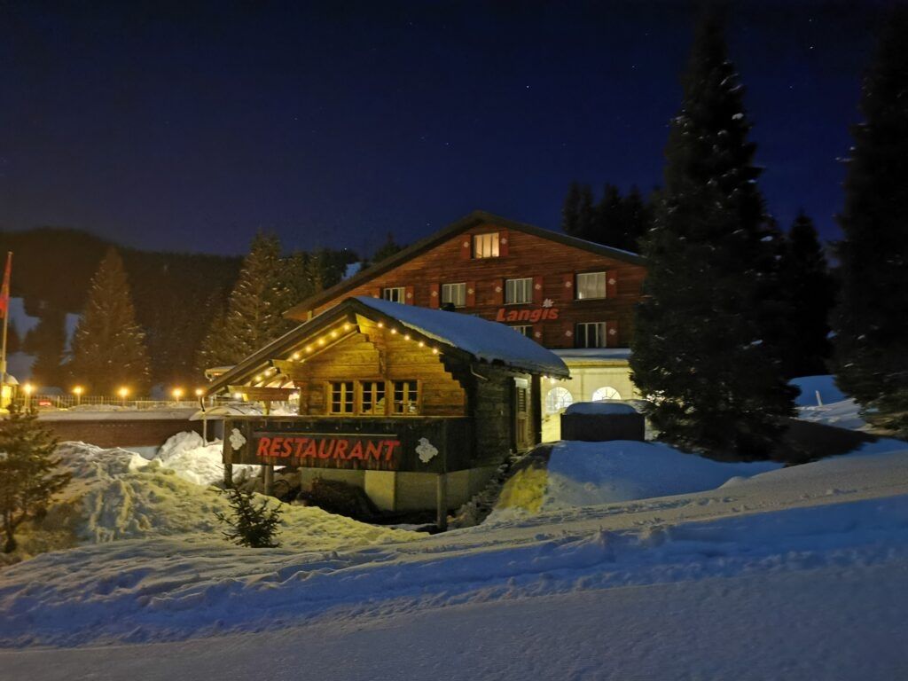 Langis in Switzerland - a small cabin in the snow at night.