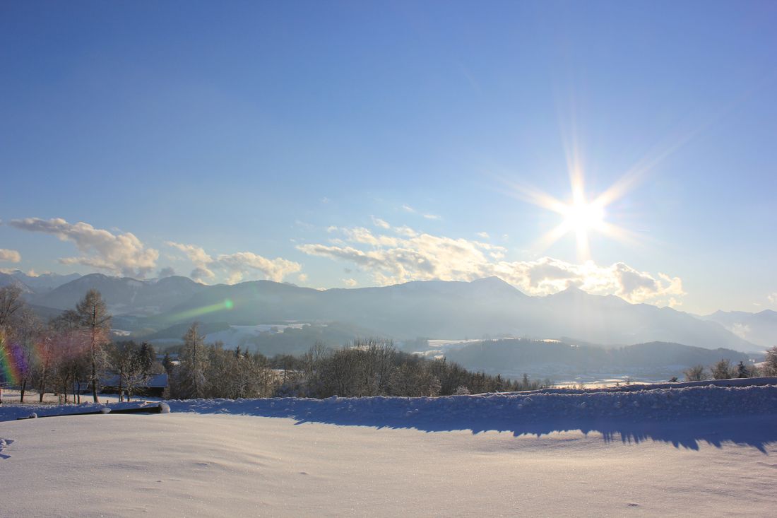 Wolfsberglift – Siegsdorf in Germany - a snow covered field with mountains in the background.