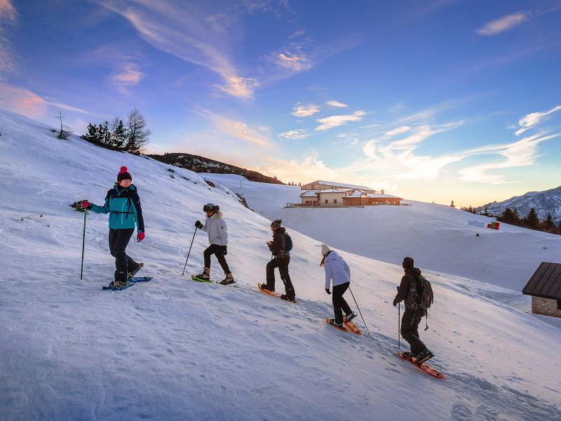 Paganella – Andalo in Italy - a group of people skiing down a snowy slope.