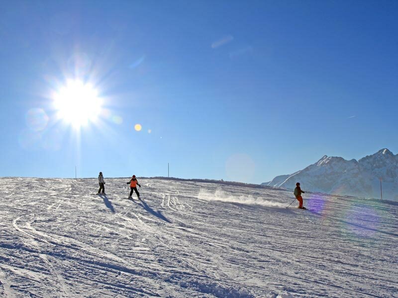 Paganella – Andalo in Italy - two people skiing down a snow covered mountain.