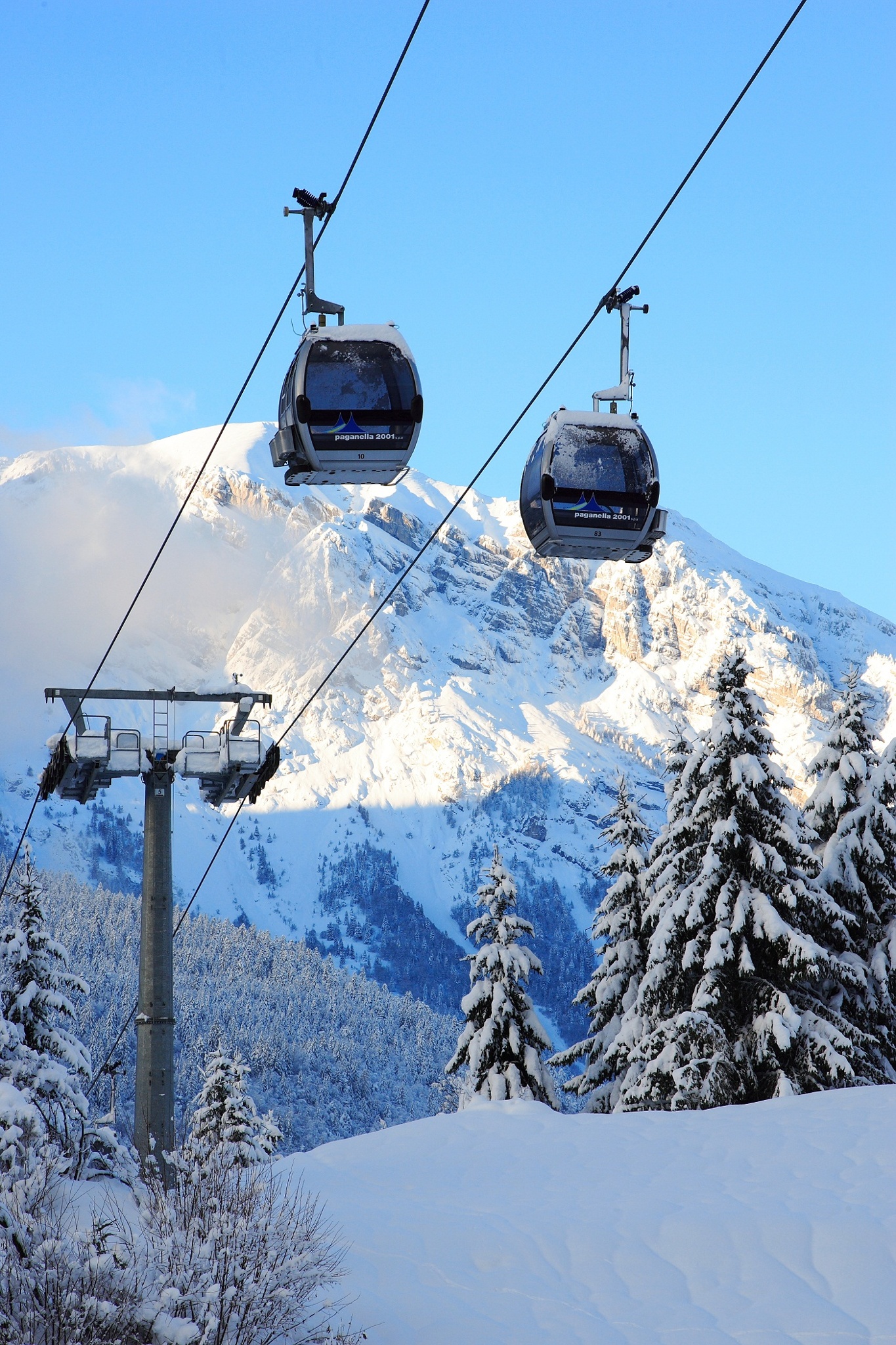 Paganella – Andalo in Italy - a ski lift going up a snowy mountain.