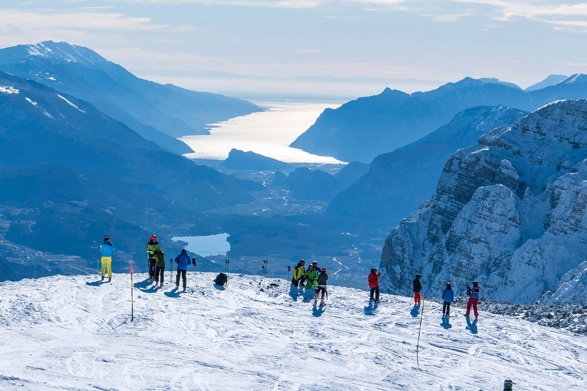 Paganella – Andalo in Italy - a group of people skiing down a mountain.