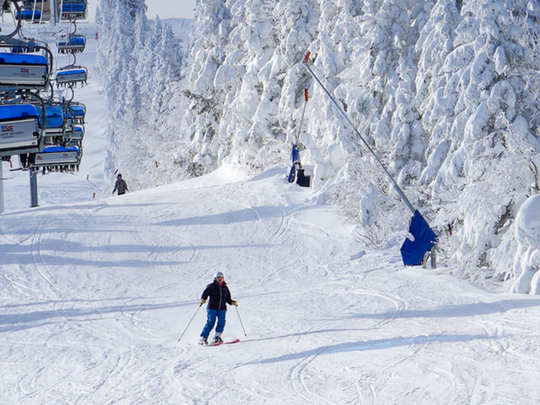 Mount Snow in USA - a group of people skiing down a snowy slope.