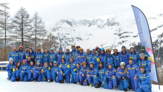 Winter scene at Wurzeralm – Spital am Pyhrn in Upper Austria, featuring a traditional chalet, a busy ski resort, and a group of people enjoying skiing.