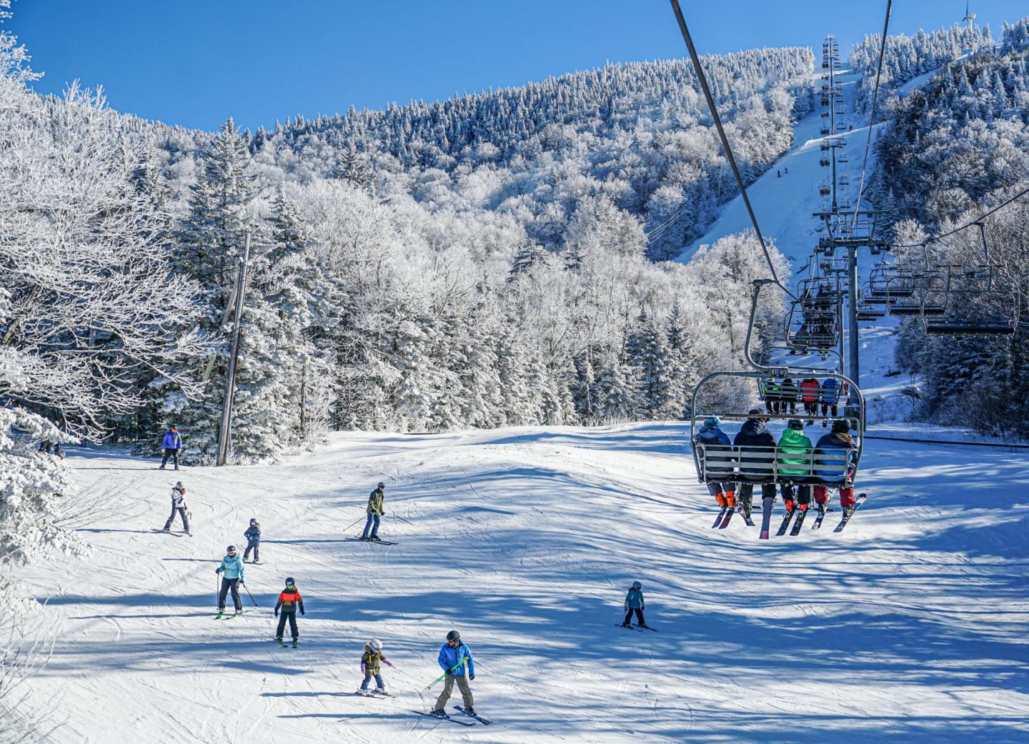 Bolton Valley in USA: people skiing on the slopes of a ski resort.