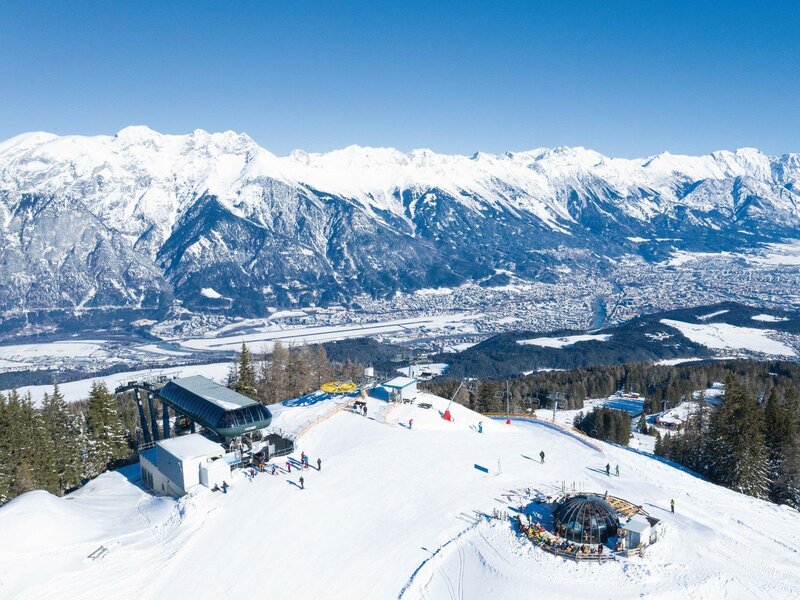 Muttereralm in Austria - a ski slope with snow covered mountains in the background.