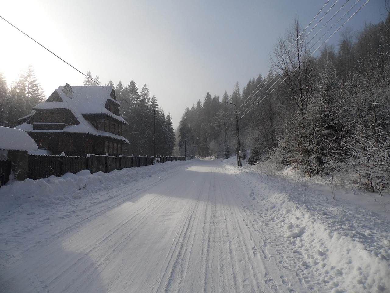 Borowice in Poland - a snow covered road with a house in the background.