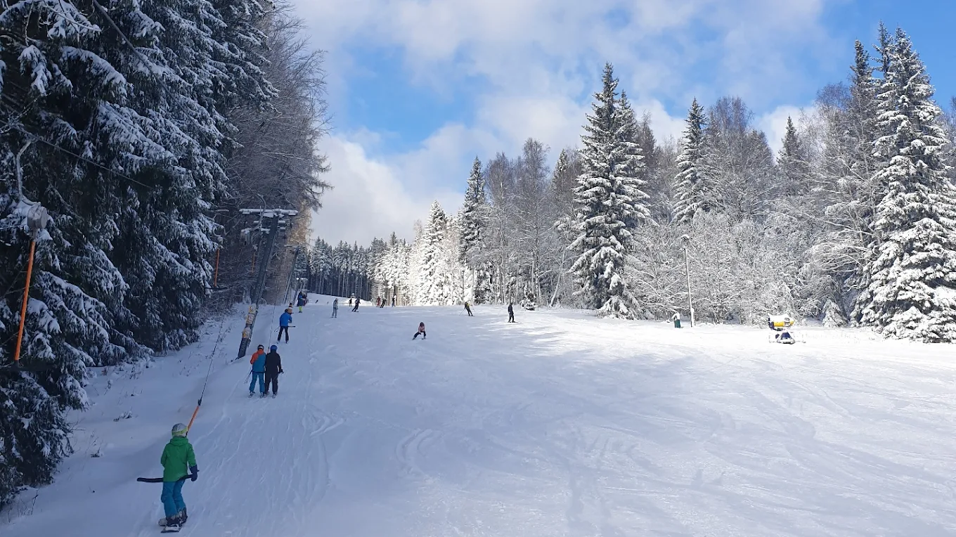 Pradědova aréna in Czech Republic - a group of people skiing down a snow covered slope.