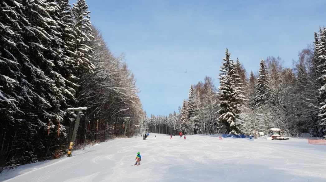 Pradědova aréna in Czech Republic - a group of people skiing down a snow covered hill.
