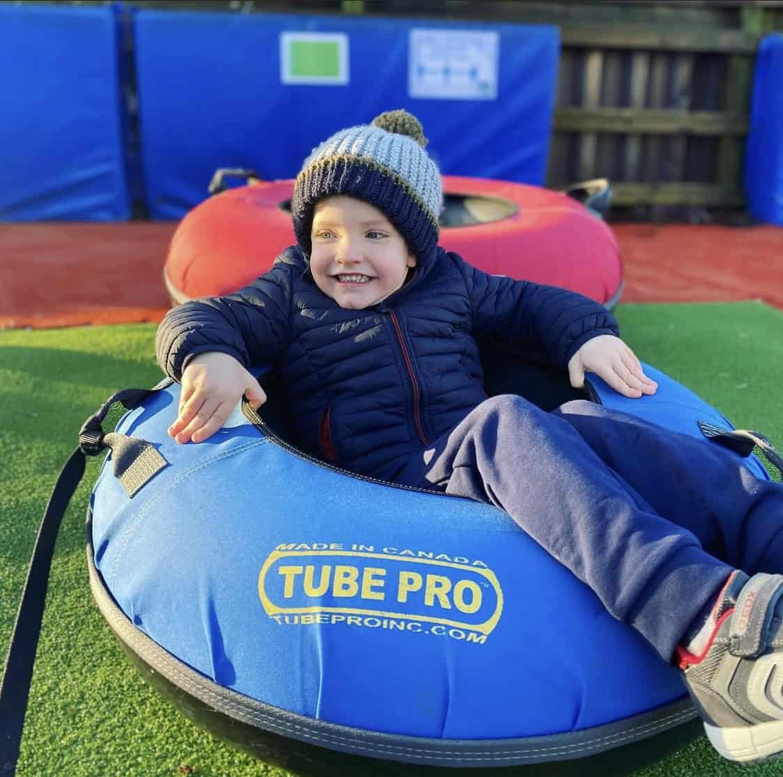 Stoke Ski Centre in United Kingdom - a young boy is sitting on a tube tube.