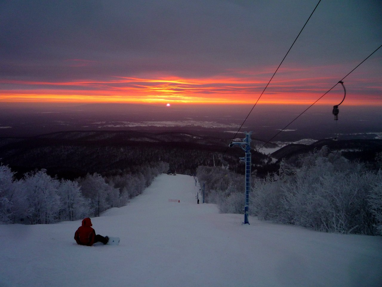 Amut Snowlake in Russia - a person sitting on top of a snow covered ski slope.