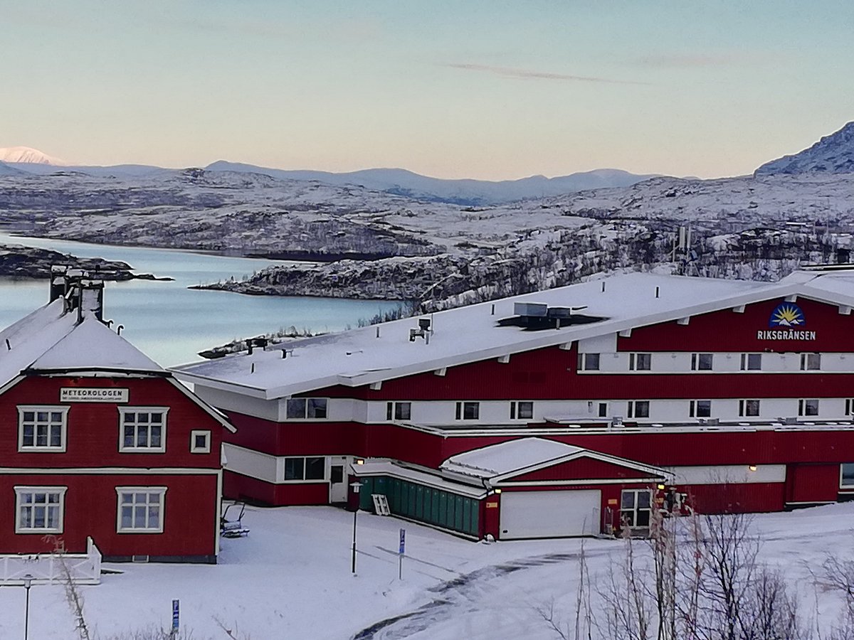 Riksgränsen in Sweden: a red building in the snow with mountains in the background.